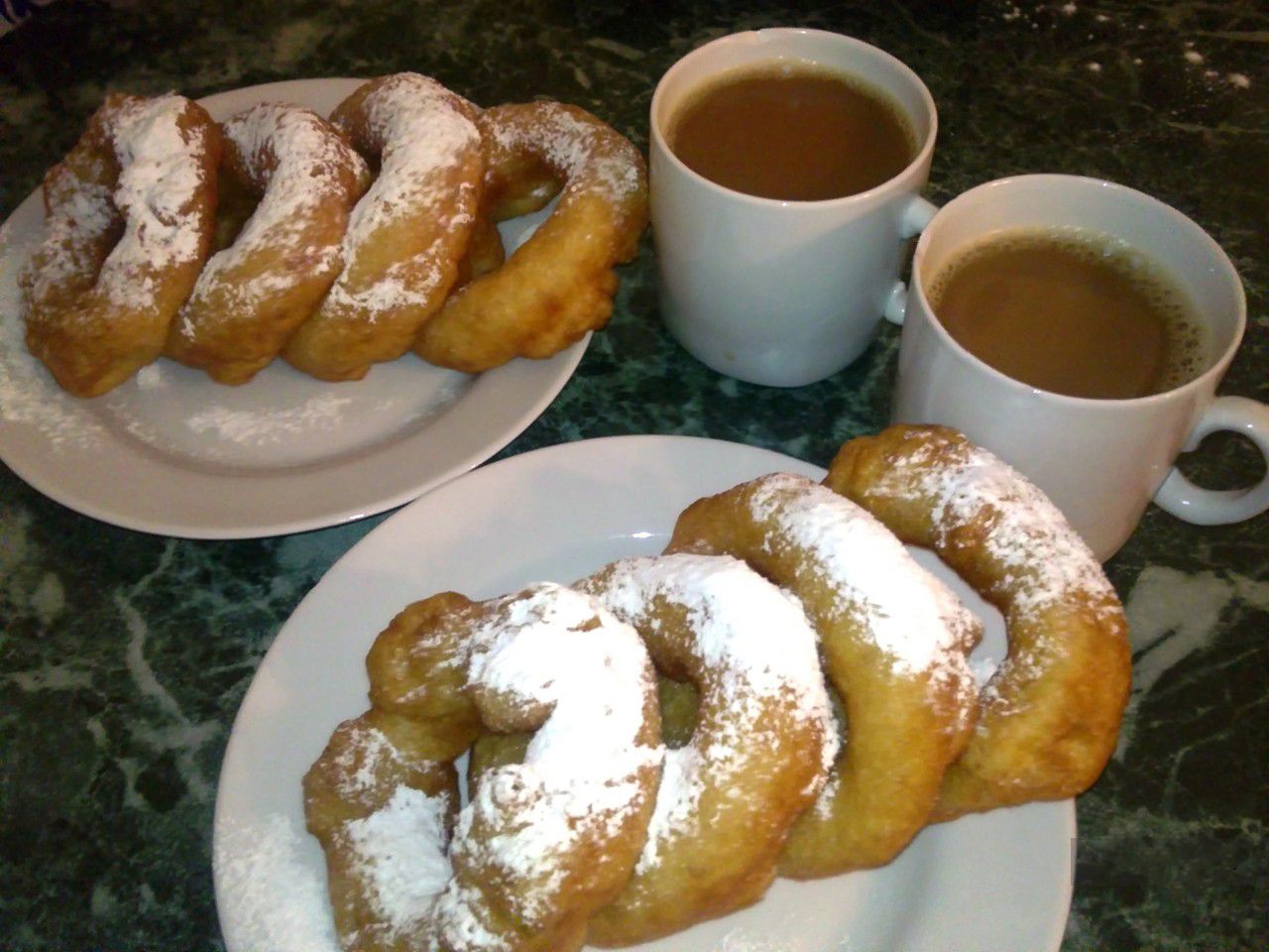pishkis are ring doughnuts dusted with powdered sugar.